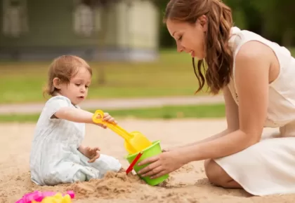 happy-mother-with-baby-girl-playing-in-sandbox-P7UCE6V-min-1024x683